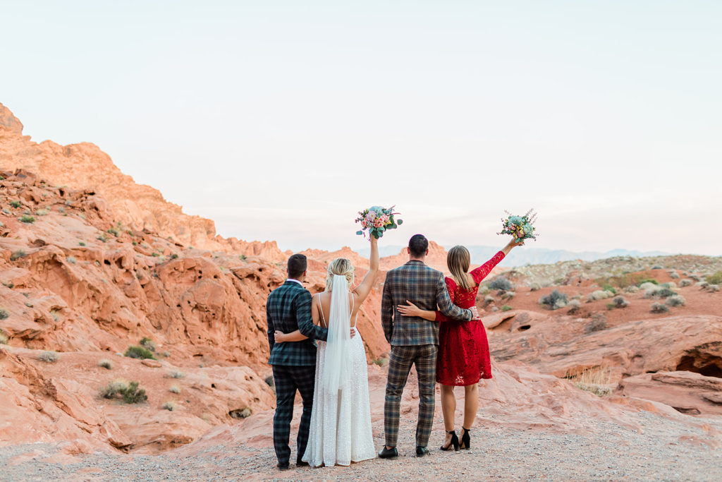 bride and groom hugging their sibling during on their wedding day