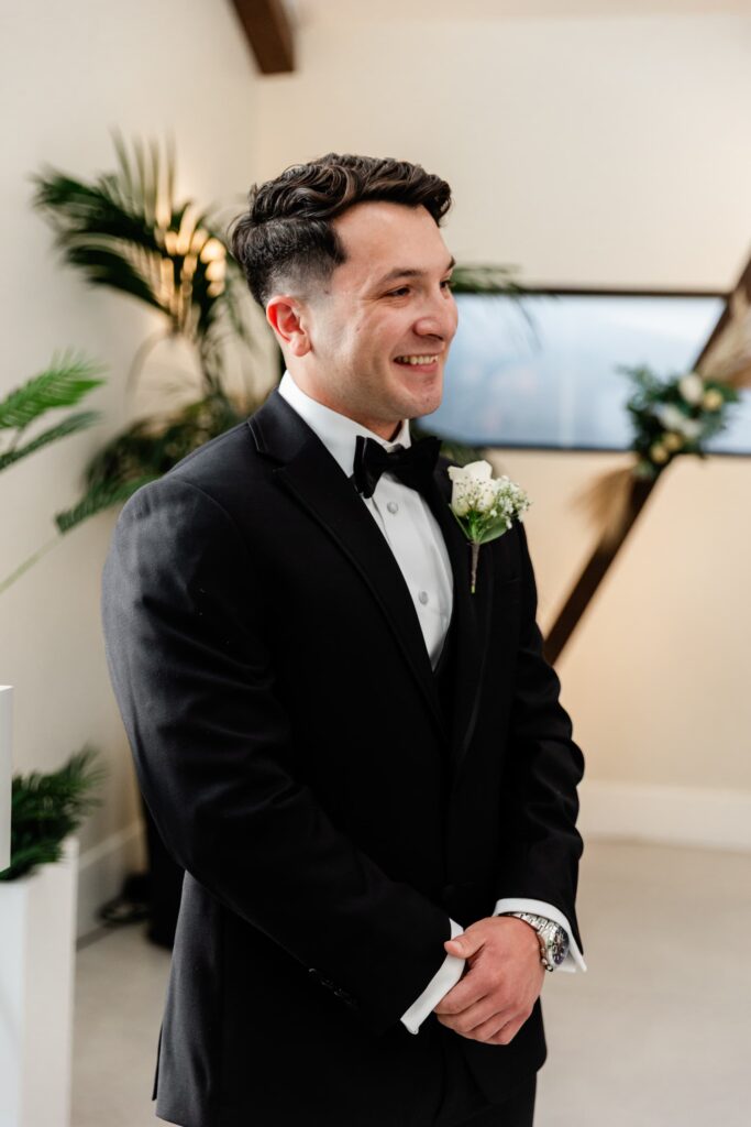 The groom smiling as his bride walks the aisle at Little Vegas Chapel